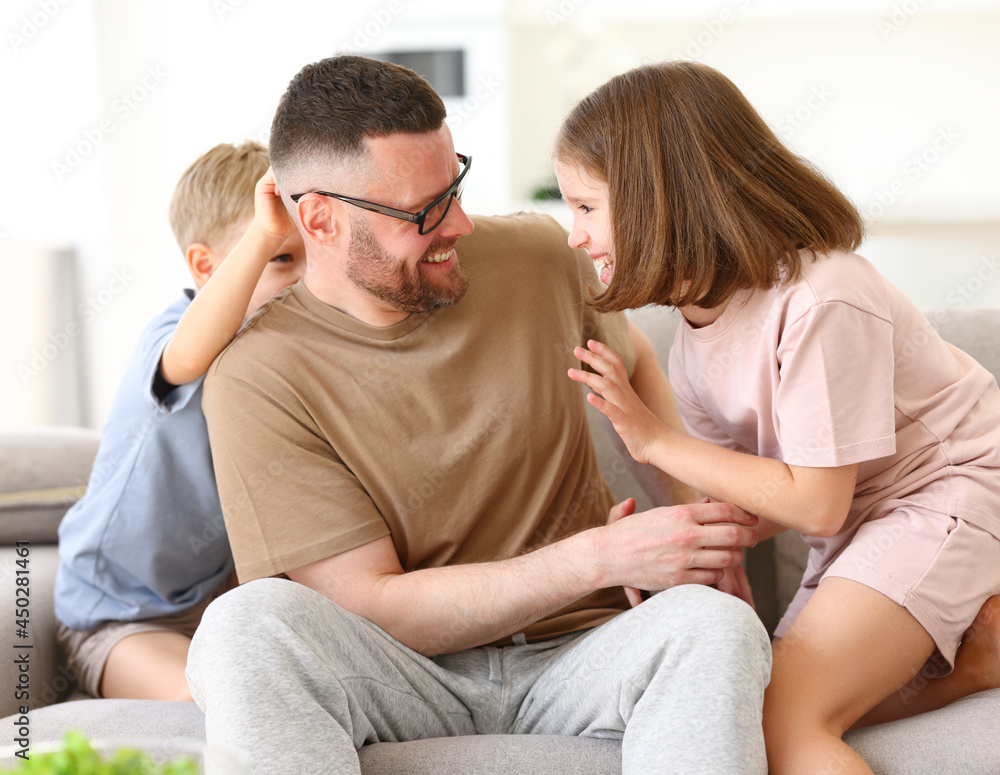 Positive happy family of three enjoying carefree time together at home, dad playing with kids Positive happy family of three enjoying carefree time together at home, dad playing with kids