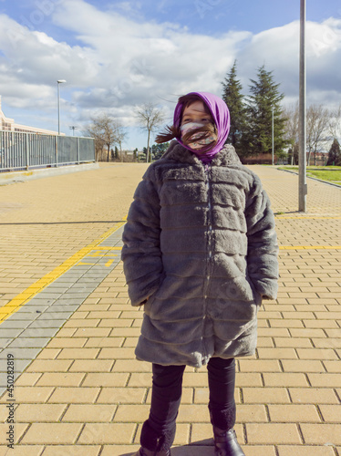 Elementary girl posing with long coat photo
