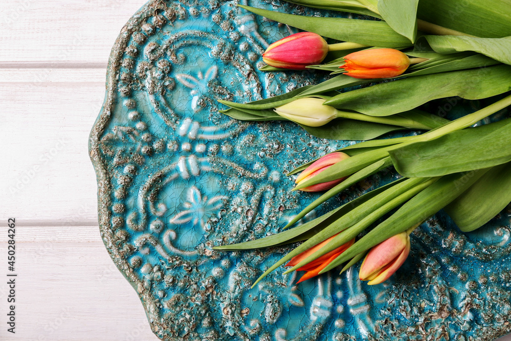 Colorful tulips on vintage ceramic surface.