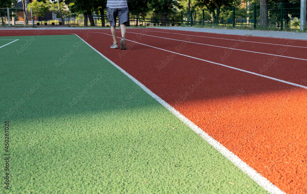 Fototapeta premium Green and red running roads and elderly runner.Morning exercises.Empty space