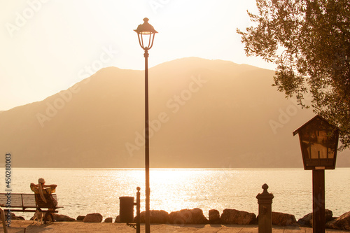 Rida del GADRA, ITALY-July 20, 2021: a girl on the Lake Garda admires the sunset photo