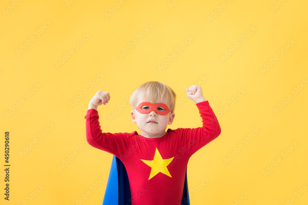 Superhero child against yellow paper backdrop Superhero child against yellow paper backdrop