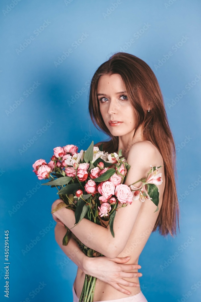 nude brunette girl holding flowers. natural beauty. on a blue background nude brunette girl holding flowers. natural beauty. on a blue background