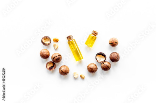 Macadamia nut oil in glass bottle with nuts. Essence extra virgin oil for food or cosmetic