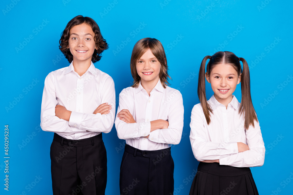 Photo of sweet adorable schoolchildren wear uniform smiling arms crossed isolated blue color background