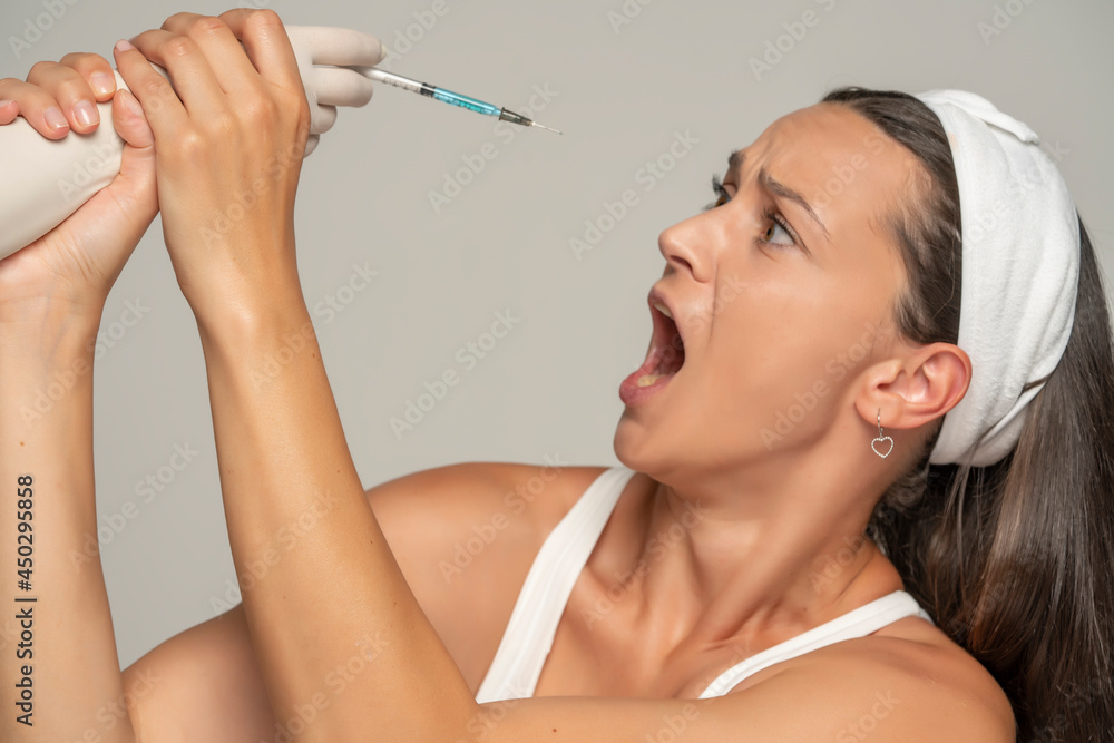 young frightened woman on a face filler injection procedure