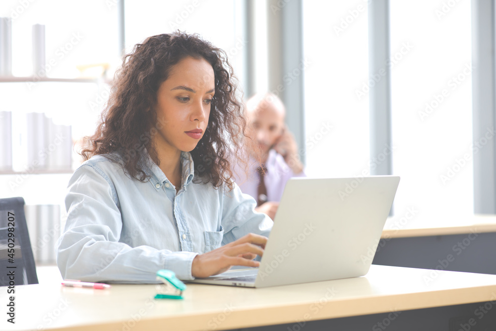 Professional business woman analyzing data on paper work and laptop computer on office desk in modern office. Professional business woman analyzing data on paper work and laptop computer on office desk in modern office.