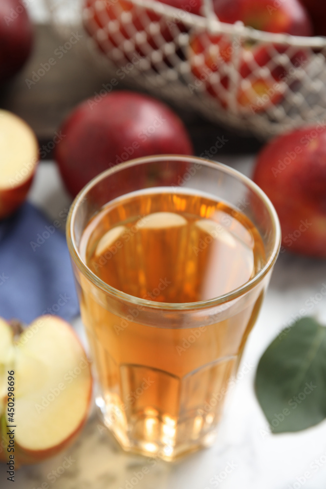 Glass of delicious apple cider on white marble table, closeup Glass of delicious apple cider on white marble table, closeup