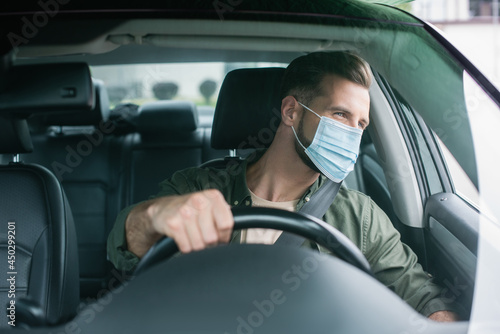 Driver in medical mask looking at window in car © LIGHTFIELD STUDIOS