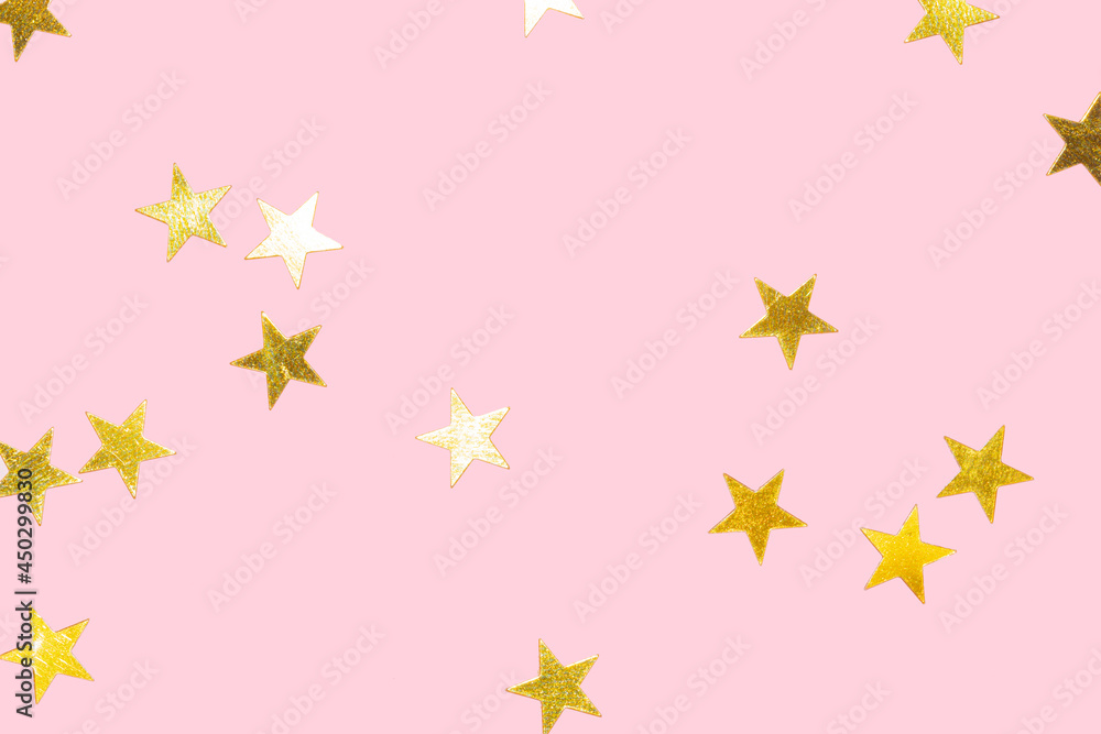 golden metallic star confetti on a pastel pink background golden metallic star confetti on a pastel pink background