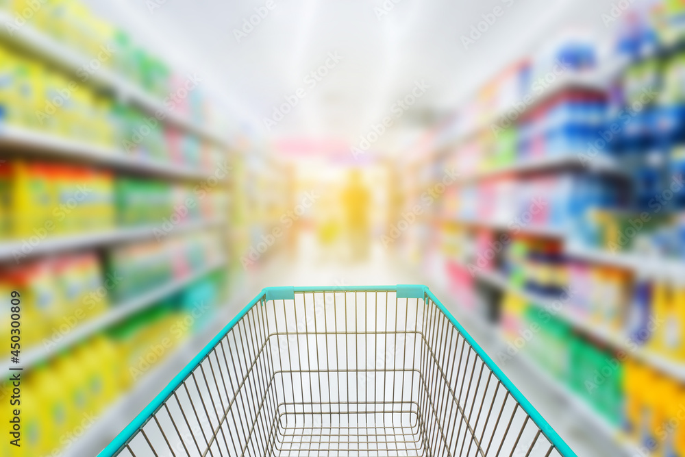 Shopping cart in blur supermarket background.