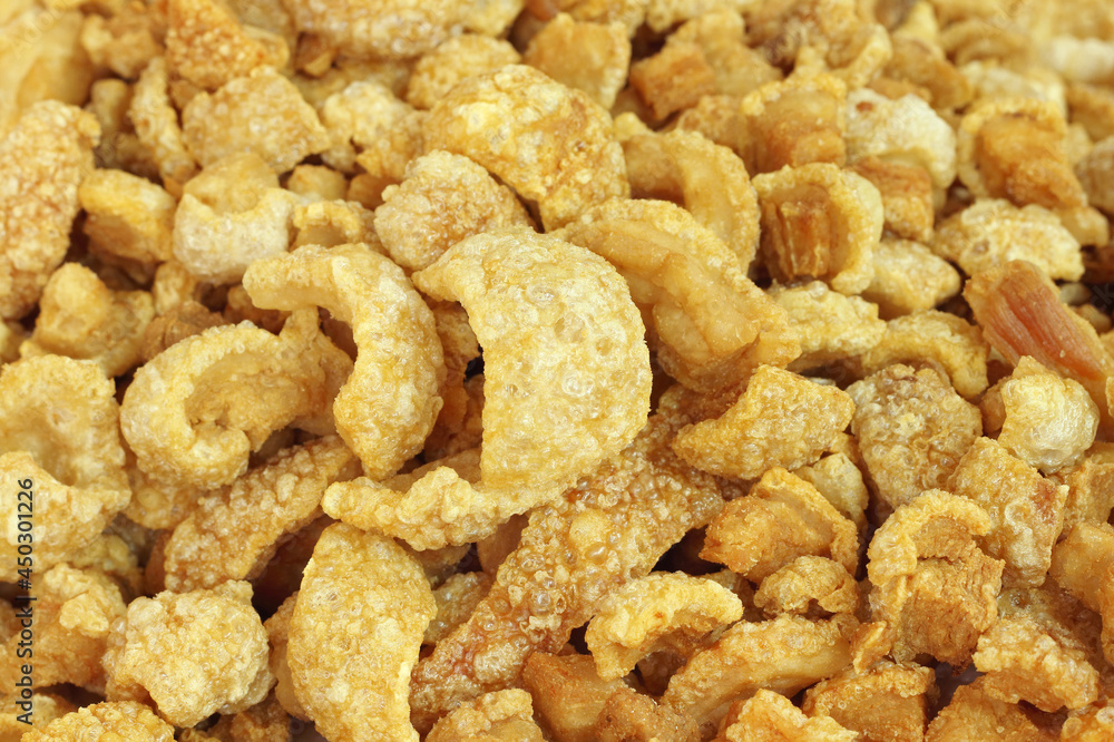 Close up of pork snack or pork scratching at market, crispy fried pork skin and blistered is traditional food in the north of Thailand. Close up of pork snack or pork scratching at market, crispy fried pork skin and blistered is traditional food in the north of Thailand.
