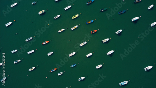 Many fishing and small boats parked on a river. Drone view. photo