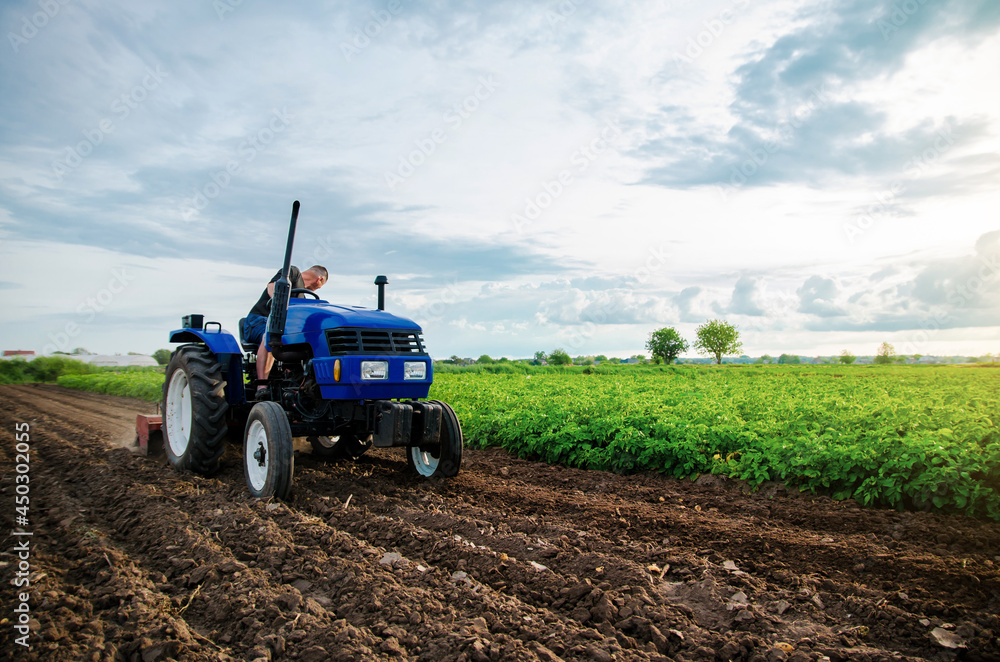 A farmer is cultivating a farm field. Seasonal worker. Recruiting workers with driving skills of agricultural machinery. Land cultivation. Farming. Small farms. Work in the agricultural industry. A farmer is cultivating a farm field. Seasonal worker. Recruiting workers with driving skills of agricultural machinery. Land cultivation. Farming. Small farms. Work in the agricultural industry.