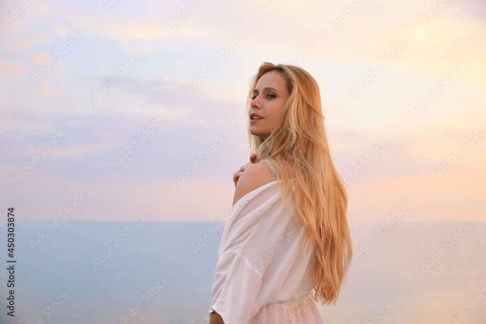 Beautiful young woman near sea in morning, space for text Beautiful young woman near sea in morning, space for text