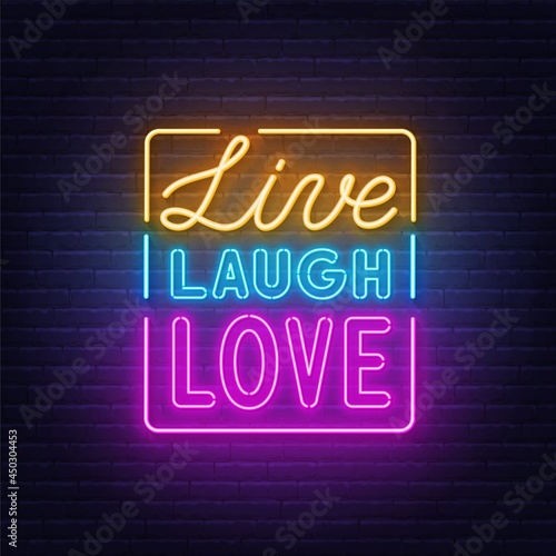 Live laugh love neon quote on brick wall background.