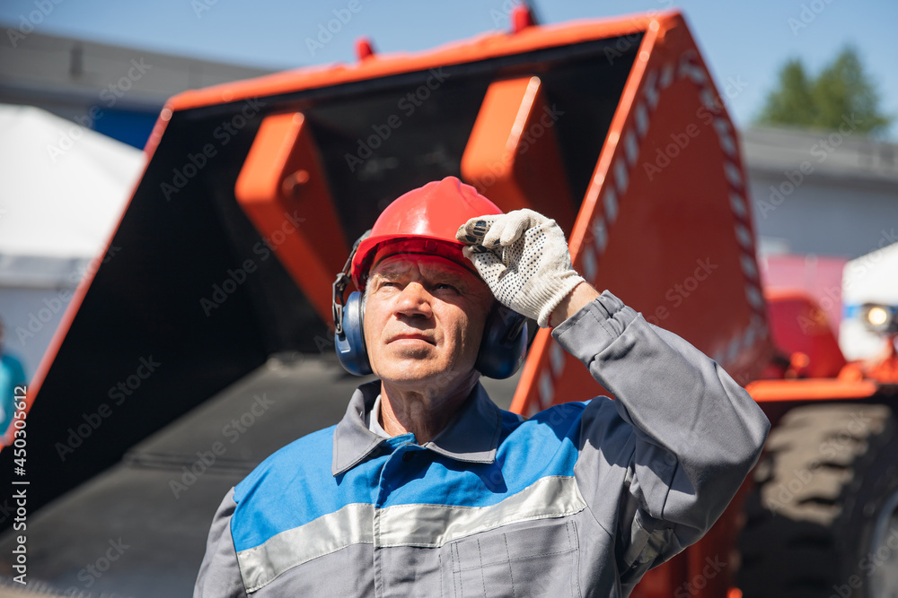 Portrait bulldozer driver Industrial worker man in protective helmet and headphones background factory Portrait bulldozer driver Industrial worker man in protective helmet and headphones background factory