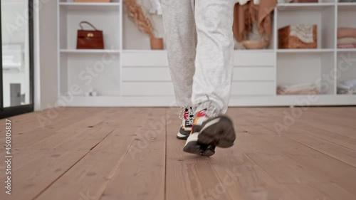 close up details woman feet in sport sneakers walks to the camera active lifestyle bedroom interior slow motion