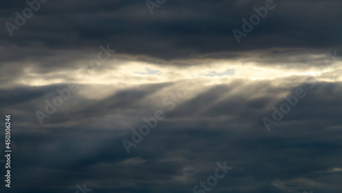 Rayos de sol en el horizonte entre las nubes. Cielo cubierto donde solo unos pocos rayos de sol atraviesan las nubes. © AngelLuis