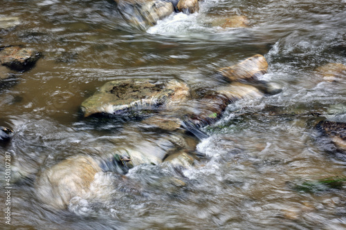 Strumyk z płynącą wodą między kamieniami.