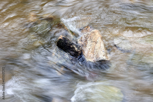 Strumyk z płynącą wodą między kamieniami.