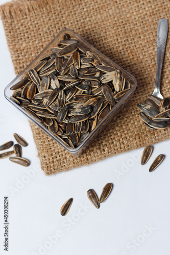 Kuaci made of sun seeds isolated on bright background. How to process sunflower seeds removed from the flower, then soaked in lime water, then drain and dry. Focus blur. Quaci Mockup. Sun seed mockup. photo