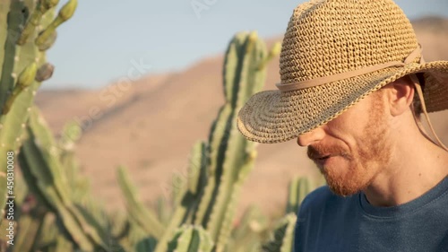 Man in a straw hat standing in a cactus desert field chewing straw in the wild wild west. Cowboy. cacti forest Desert Golan heights Israel. Kubo. lonely wolf guy outcast.