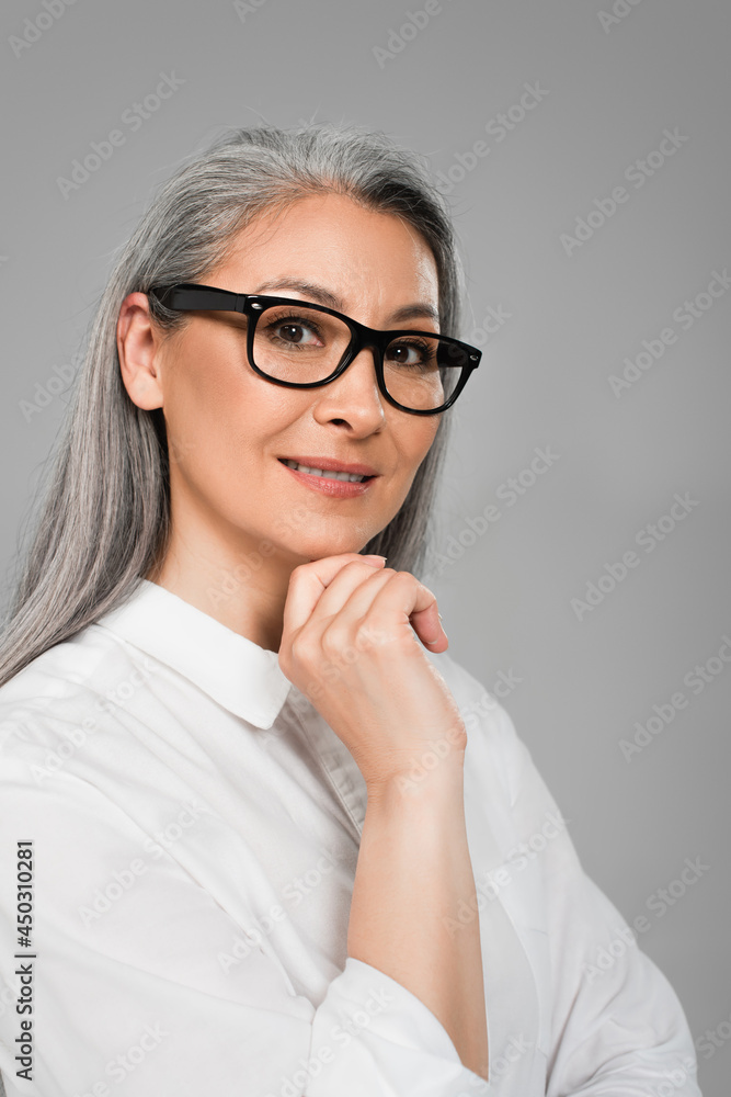 middle aged woman in stylish eyeglasses smiling at camera isolated on grey middle aged woman in stylish eyeglasses smiling at camera isolated on grey