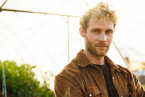 Smiling organic farmer standing in a greenhouse © Drobot Dean