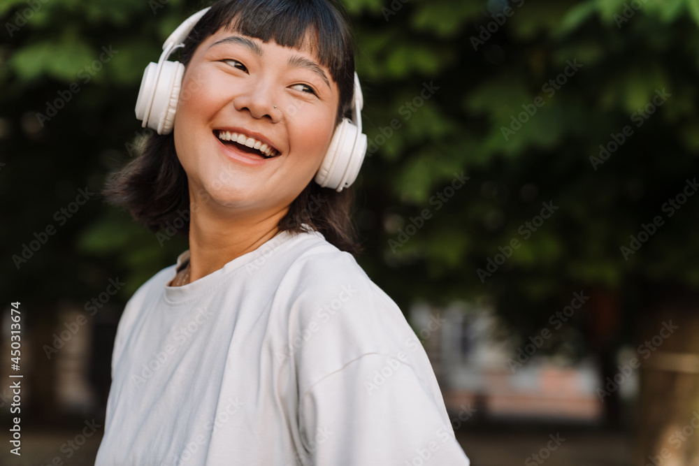 Smiling young asian woman walking in a green park Smiling young asian woman walking in a green park