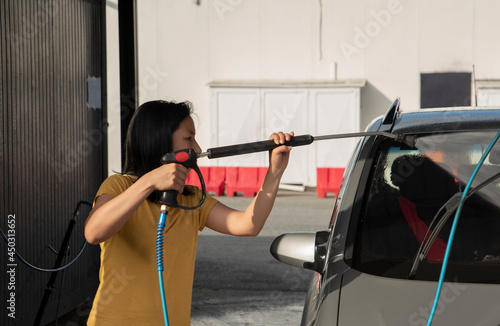 woman washing the car in a car wash