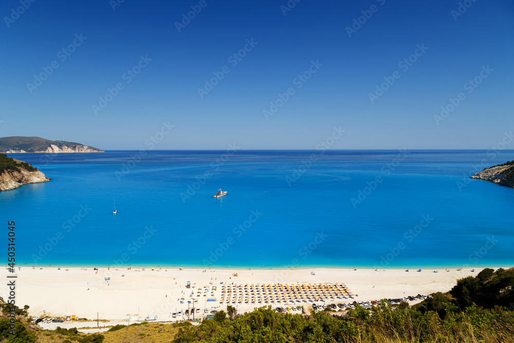 Fantastic panoramic top view at Myrtos Beach with turquoise and blue Ionian Sea water. Summer scenery of famous and extremely popular travel destination in Cephalonia, Greece, Europe.