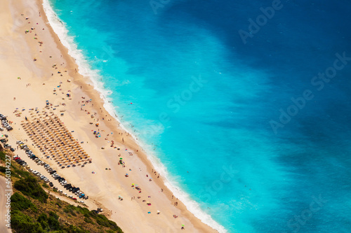 Top view at Myrtos Beach with turquoise and blue Ionian Sea water. Summer scenery of famous and extremely popular travel destination in Cephalonia, Greece, Europe.