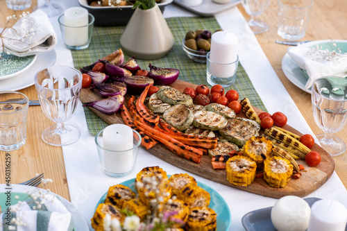 Baked vegetables and bread in the center of served table ready for outdoor lunch