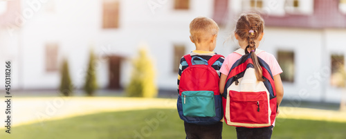 Children with backpacks going to the school photo