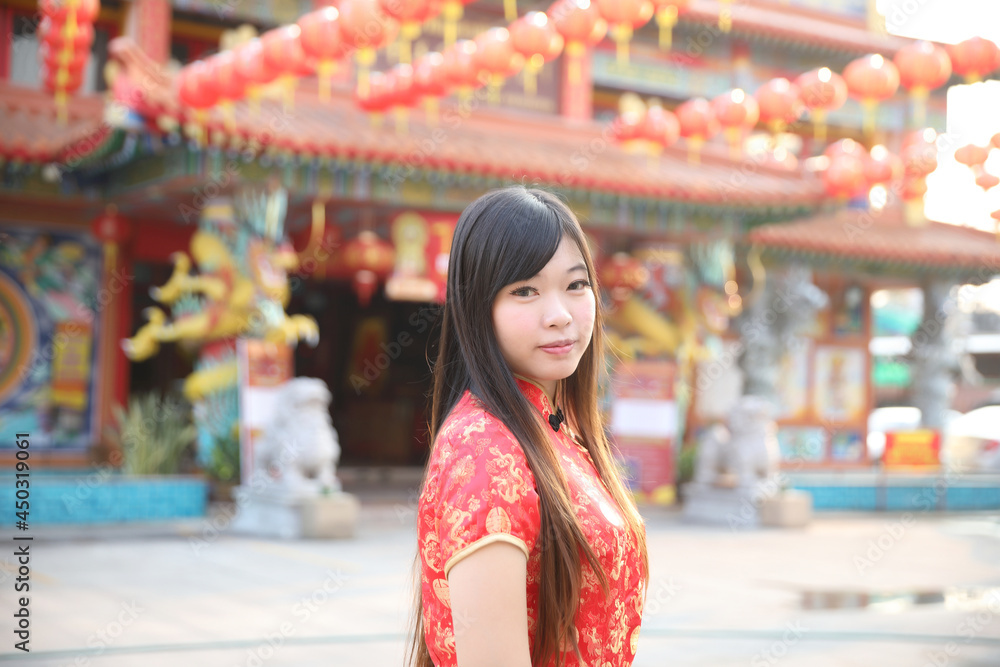 beauty woman wear red cheongsam looking and smile in chinese new year