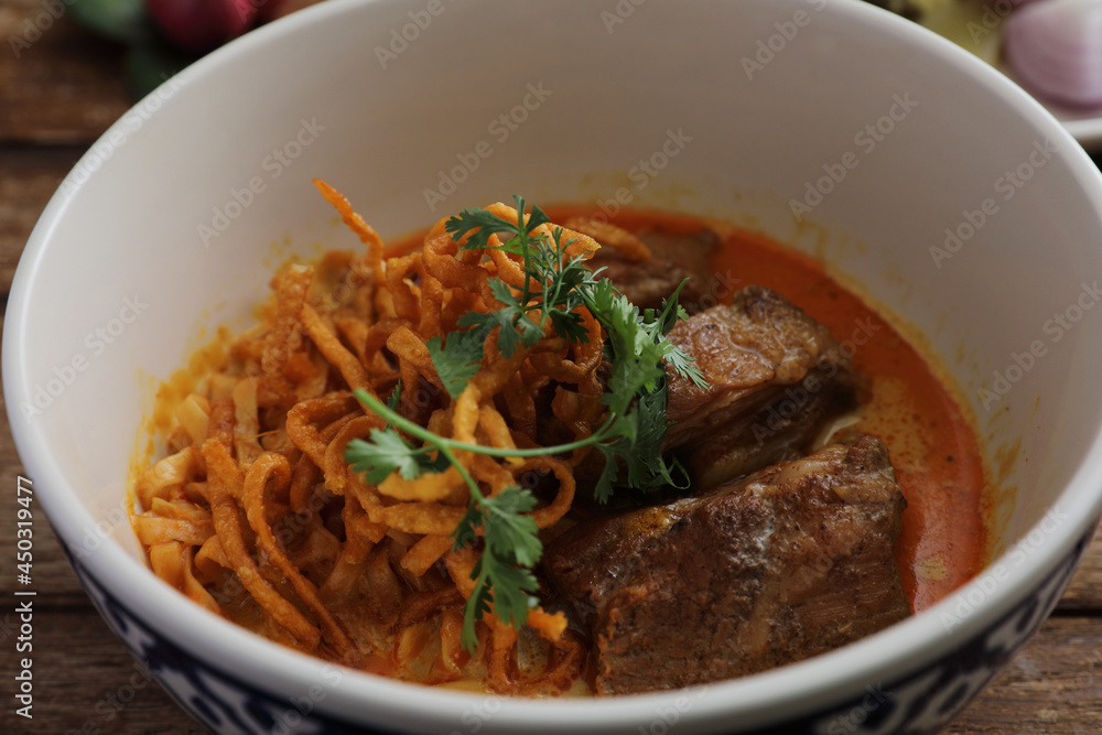 Local northern Thai food Egg noodle curry with pork ribs on wood background Local northern Thai food Egg noodle curry with pork ribs on wood background