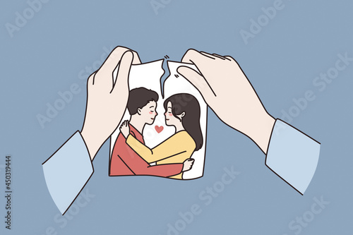 Relationship crisis, broke up concept. Human Hands holding torn photo of couple in love meaning separation or divorce over blue background vector illustration  photo