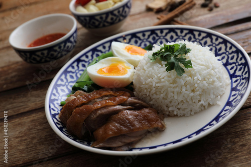 Local Thai food stewed pork leg on rice isolated in wood background