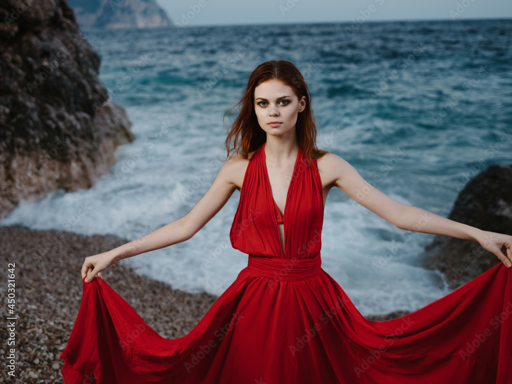 woman in red dress posing shore rocks ocean nature woman in red dress posing shore rocks ocean nature
