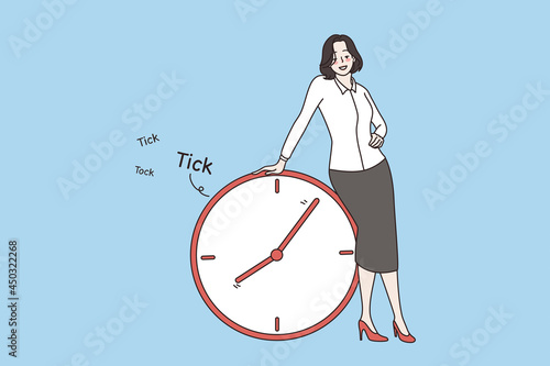 Time management and deadline concept. Young smiling businesswoman cartoon character standing and touching huge alarm clock with running time vector illustration 