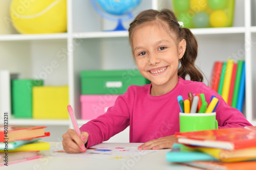 Porait of cute girl drawing picture at home