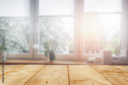 A large window with morning sun rays and an empty table 