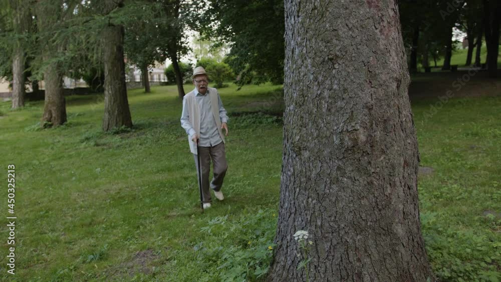 Old man leans on a tree because of heart pain Old man leans on a tree because of heart pain