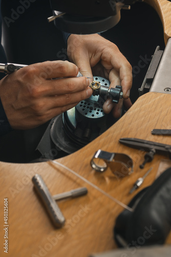 Goldsmith at work. Jeweler's workbenche with different tools. Desktop for craft jewelry making with professional tools.