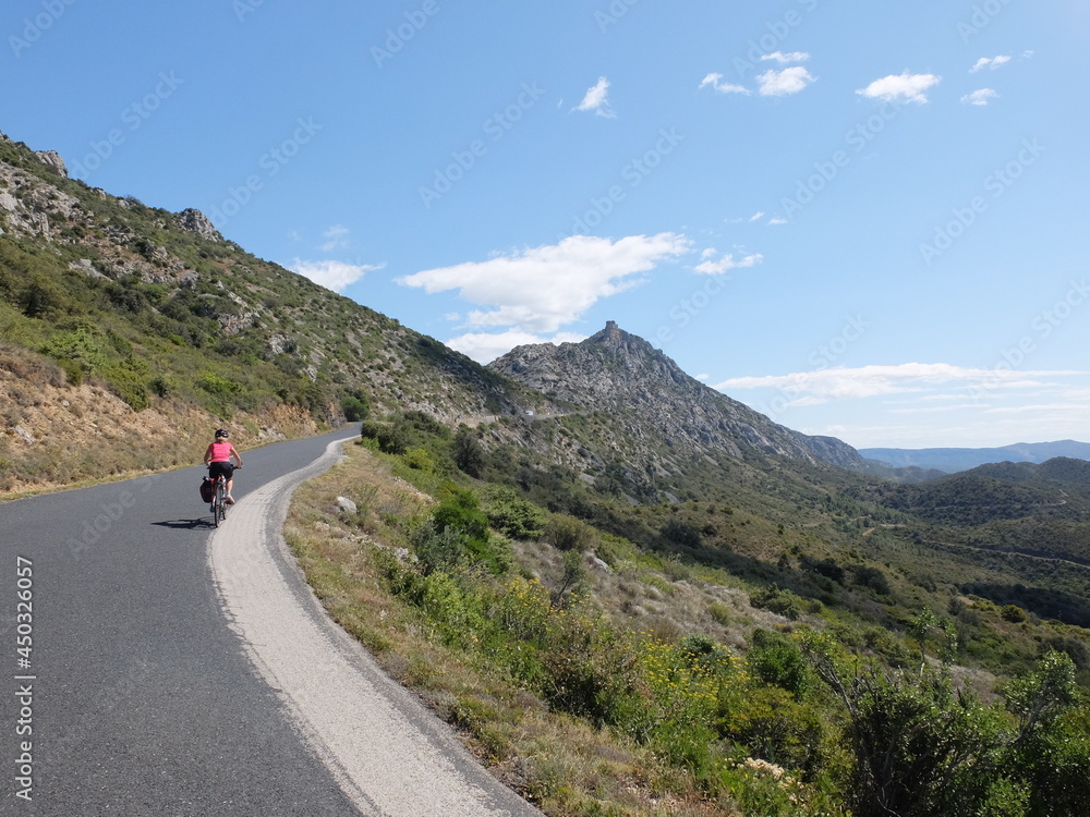 Naklejka premium jeune femme à vélo qui randonne en itinérant à bicyclette dans le sud de la France