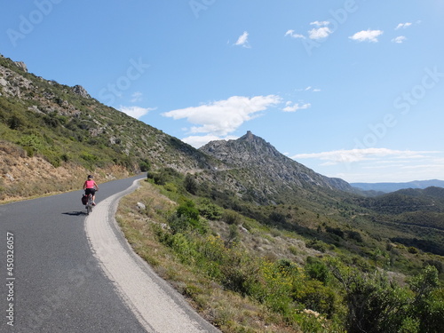 jeune femme à vélo qui randonne en itinérant à bicyclette dans le sud de la France