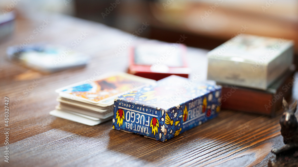 Fototapeta premium Blurred Tarot cards on the table, esoteric concept, fortune telling and predictions