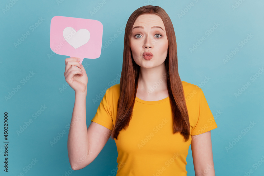 Portrait of romantic adorable lady hold heart icon card send air kiss on blue background