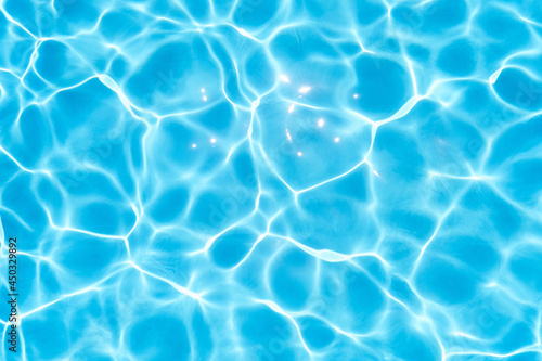 Blue water in the pool glows under the rays of the sun. Close-up